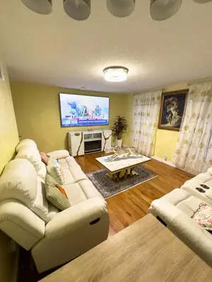 a living room with a white couch and a flat screen tv at Sleeps 4 Guests Near Yale & Downtown - Free Parking in New Haven