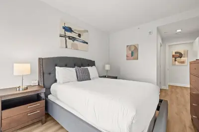 a bedroom with a large white bed and a desk at Luxury Modern Apartment Near Stamford Station in Stamford