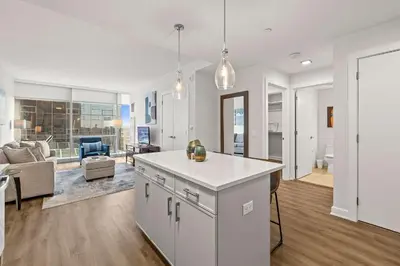 a kitchen and living room with a couch and a table at Luxury Modern Apartment Near Stamford Station in Stamford