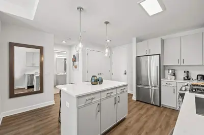 a kitchen with white cabinets and a white counter top at Luxury Modern Apartment Near Stamford Station in Stamford