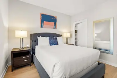 a bedroom with a large bed and a nightstand with two lamps at Luxury Urban Escape Walk to Downtown in Stamford