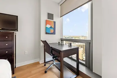 a bedroom with a desk and a large window at Luxury Urban Escape Walk to Downtown in Stamford