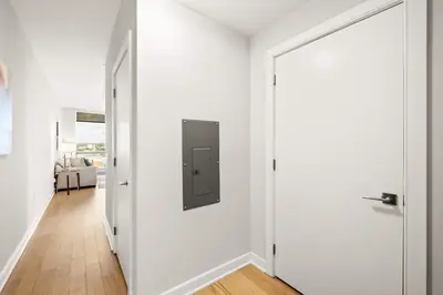 a white hallway with a door with a metal box on it at Luxury Urban Escape Walk to Downtown in Stamford