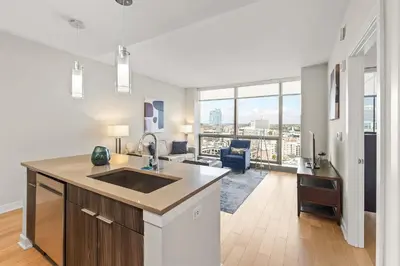 a kitchen with a sink and a living room at Luxury Urban Escape Walk to Downtown in Stamford