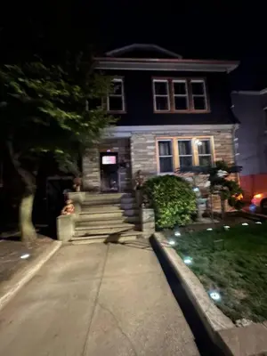 a house at night with a person standing in front of it at 3 Large Bedrooms Luxe Artistic Art Vibe in Newark