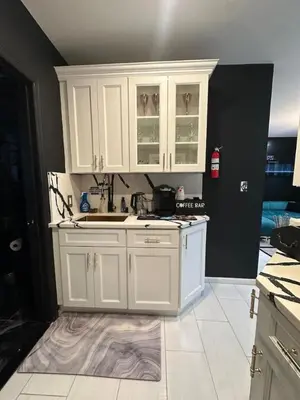a kitchen with white cabinets and a white tile floor at 1 Large Bedroom Contemporary Luxe Stay in Newark