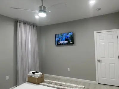 a living room with a tv on the wall at 7 Large Bedrooms Art-Inspired Art House in Newark