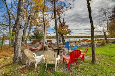 a group of chairs sitting around a fire pit at Lakefront Pocono Retreat with Hot Tub and Movie Hub in Pocono Summit