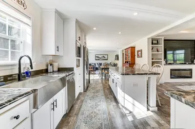a kitchen with white cabinets and marble counter tops at 8 Mi to Jiminy Peak Resort Mtn-View Home with Deck in Stephentown