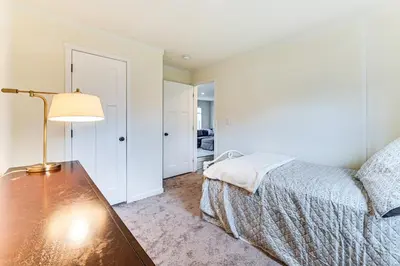 a bedroom with a bed and a table with a lamp at 8 Mi to Jiminy Peak Resort Mtn-View Home with Deck in Stephentown