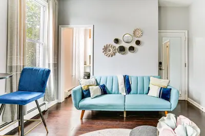 a living room with a blue couch and two chairs at Explore and Work! Stylish Washington Heights Duplex in Newburgh