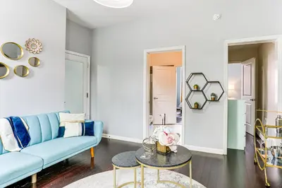 a living room with a blue couch and a table at Explore and Work! Stylish Washington Heights Duplex in Newburgh