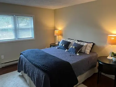 a bedroom with a bed with blue blankets and pillows at In the middle of everything in Saratoga Springs
