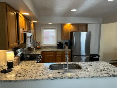 a kitchen with a sink and a stainless steel refrigerator at In the middle of everything in Saratoga Springs