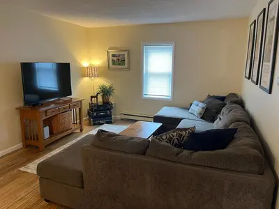a living room with a couch and a flat screen tv at In the middle of everything in Saratoga Springs