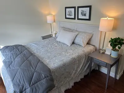 a bedroom with a bed with two lamps and a table at In the middle of everything in Saratoga Springs