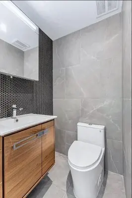 a bathroom with a white toilet and a sink at Duplex Dream 4-Bedroom Bonbon in New York