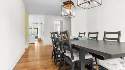 a dining room with a black table and chairs at Modern Berkshires Farmhouse w Porch Fireplace Views Beaver Creek by AvantStay in Stockbridge