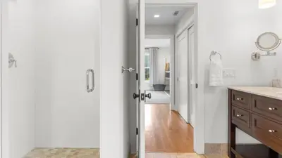 a bathroom with a door leading to a hallway at Modern Berkshires Farmhouse w Porch Fireplace Views Beaver Creek by AvantStay in Stockbridge