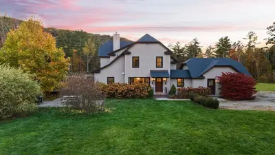 a large white house with a yard at Modern Berkshires Farmhouse w Porch Fireplace Views Beaver Creek by AvantStay in Stockbridge