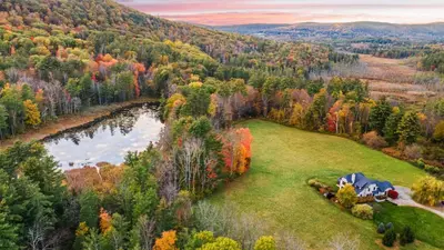 an aerial view of a tent in a field next to a lake at Modern Berkshires Farmhouse w Porch Fireplace Views Beaver Creek by AvantStay in Stockbridge