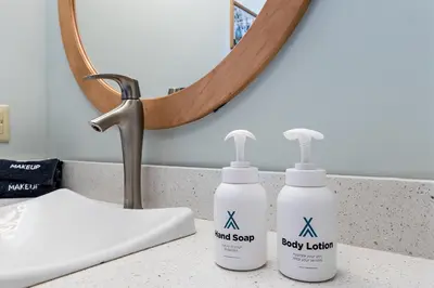 two bottles of soap on a bathroom counter in front of a mirror at Pinnacle Pointe by Relaxtay 600 Acre Private Luxury Estate with Spa, Pool, Theater and Lake in Middletown