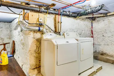 a washer and dryer in a room with pipes at 1 Mi to Main St Riverside Torrington Apt with Yard in Torrington