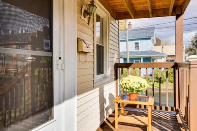 a porch with a wooden chair and a window at 1 Mi to Main St Riverside Torrington Apt with Yard in Torrington