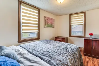 a bedroom with a bed and two windows at 1 Mi to Main St Riverside Torrington Apt with Yard in Torrington
