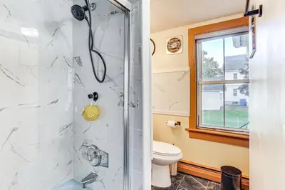a bathroom with a shower and a toilet at 1 Mi to Main St Riverside Torrington Apt with Yard in Torrington