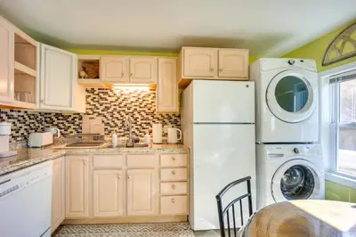a kitchen with a refrigerator and a washer and dryer at Riverfront Apt with Fire Pit and Yard in Millers Falls