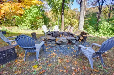 a group of chairs sitting around a fire pit at Riverfront Apt with Fire Pit and Yard in Millers Falls