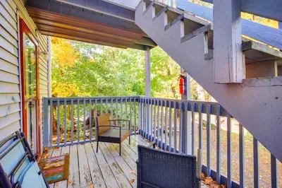 a balcony with a table and chairs on a porch at Riverfront Apt with Fire Pit and Yard in Millers Falls