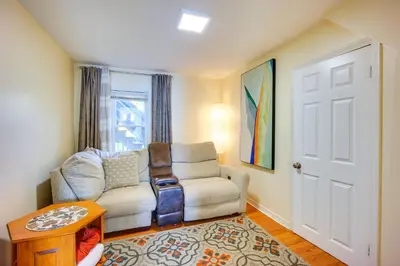 a living room with a chair and a table at Riverfront Apt with Fire Pit and Yard in Millers Falls