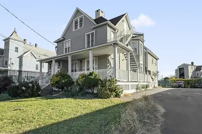 a large house with a white fence on a street at Harbor Haven, Apt #1 Studio in Stamford