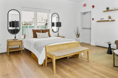 a bedroom with a bed and a bench and a window at Harbor Haven, Apt #1 Studio in Stamford
