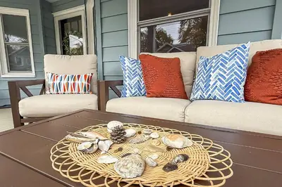 a coffee table on a porch with a couch and pillows at Plymouth Court Turret Retreat in Milford