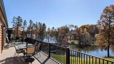 a deck with chairs and a view of a lake at Peaceful Lakefront Cabin in the Catskills cabin in Athens