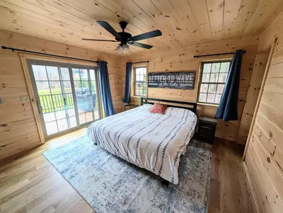 a bedroom with a bed and a ceiling fan at Peaceful Lakefront Cabin in the Catskills cabin in Athens