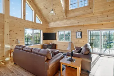 a living room with two leather couches and a television at Peaceful Lakefront Cabin in the Catskills cabin in Athens
