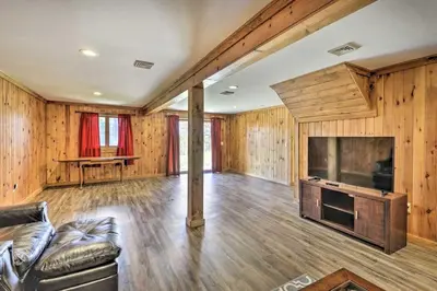 a living room with a couch and a large television at Family Cabin and Suite Near Elk Mountain Ski Slopes in Pleasant Mount