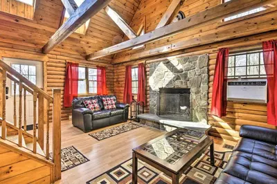 a living room with a fireplace in a log cabin at Cozy Cabin and Suite Near Ski Resort in Pleasant Mount