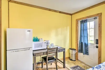 a kitchen with a table with a microwave and a refrigerator at Cozy Cabin and Suite Near Ski Resort in Pleasant Mount