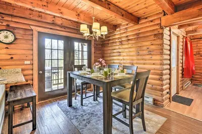 a dining room with a table and chairs in a cabin at Log Cabin and Cottage Near Elk Mountain Ski Slopes in Pleasant Mount