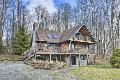 a large wooden house with a large deck at Log Cabin and Suite Close to Ski Adventures in Pleasant Mount