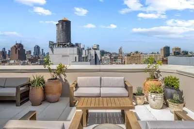 a balcony with a couch and a view of a city at Freeman 303 by Rove Travel - 1BR Condo with Shared Amenities in New York