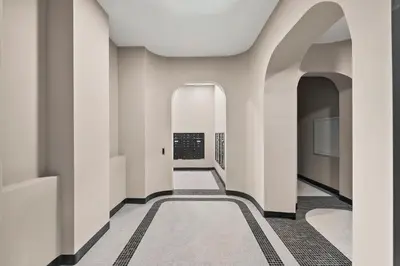 a hallway of a building with white walls and a carpet at Freeman 303 by Rove Travel - 1BR Condo with Shared Amenities in New York