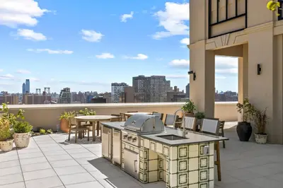 an outdoor kitchen on a patio with a view of the city at Freeman 801 by Rove Travel - Studio with Shared Amenities in New York
