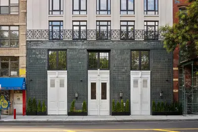 a brick building with white doors on a street at Freeman 801 by Rove Travel - Studio with Shared Amenities in New York