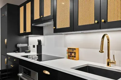 a kitchen with black cabinets and a sink at Freeman 801 by Rove Travel - Studio with Shared Amenities in New York